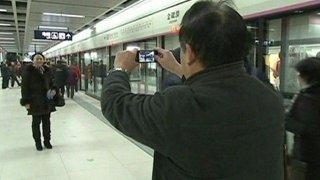 Passengers pose for pictures on the new subway line
