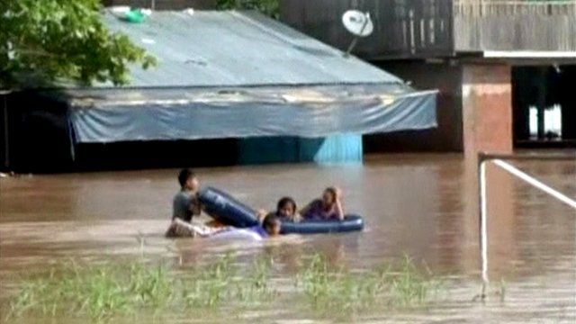 People in dinghy in flooded street
