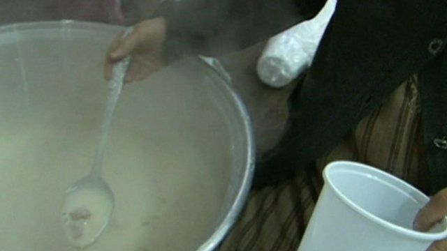 Woman ladling soup into a cup