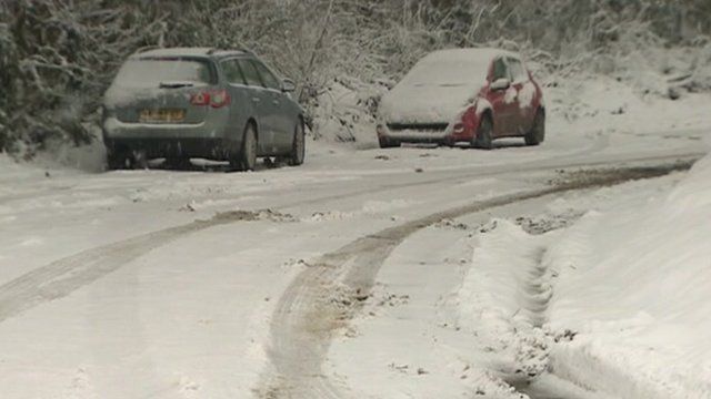 Snow covered cars on road