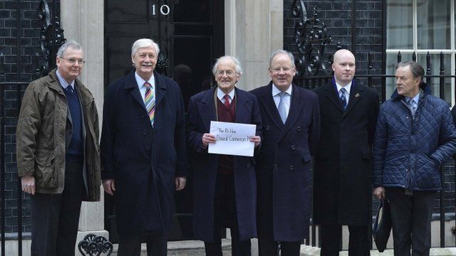 Senior local Conservatives pose for a photograph with a letter addressed to Britain"s Prime Minister David Cameron