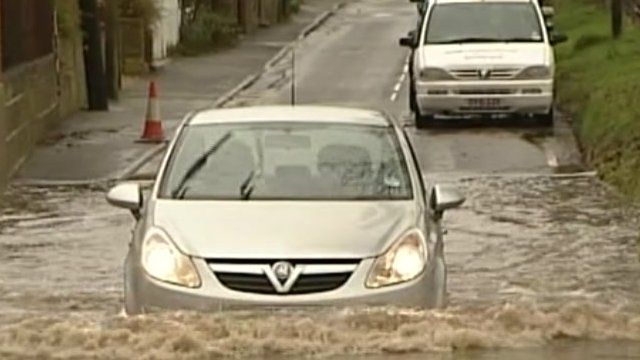 Cars negotiate deep floodwater in south-east England in December 2012