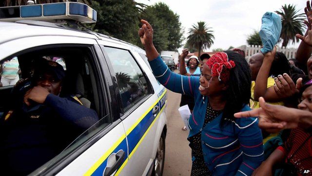 Residents shout at a police vehicle as they protest the death of taxi driver Mido Macia