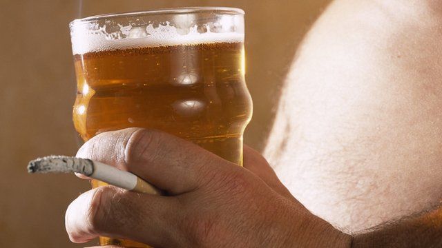 Man with beer belly, pint and a cigarette