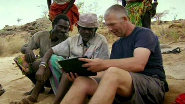 Richard Gibson shows Samburu farmers his cows on a laptop