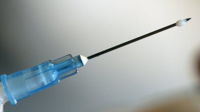 A nurse prepares a dose of H1N1 flu vaccine