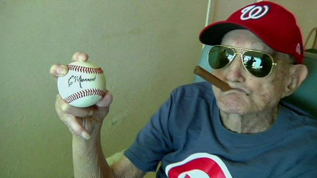 Connie Marrero posing with a self-autographed baseball
