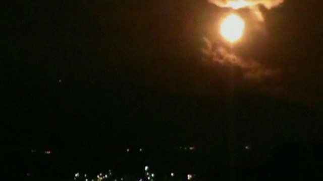A still from unverified amateur footage shows the night sky lit up, apparently in Damascus