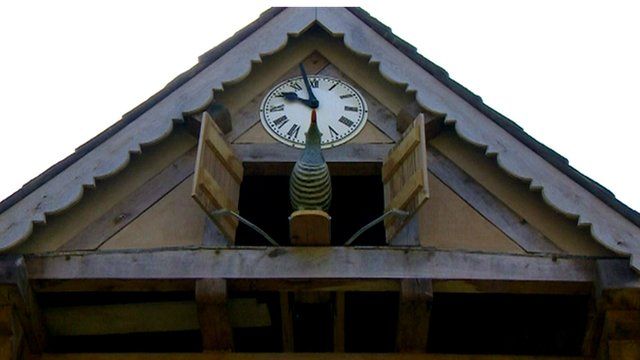 A wooden cuckoo coming out of a giant cuckoo clock