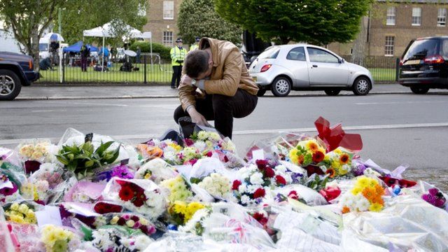 A man pays his respects as he looks at floral tributes outside Woolwich Barracks in London