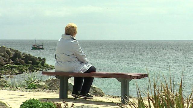 Woman on bench overlooking sea