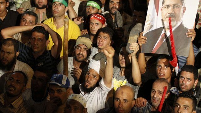 Supporters of Egypt"s ousted president Mohammed Morsi react after the Minister of Defence's announcement on state television Wednesday, July 3, 2013