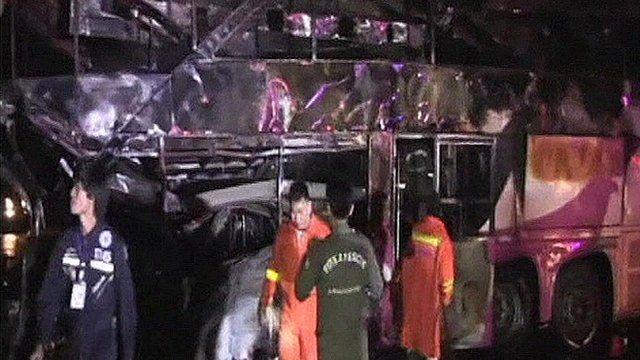 Rescue workers in front of the burnt-out bus