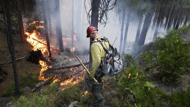 A fire fighter monitors a fire near Yosemite National Park