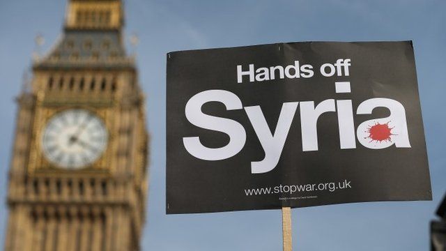 A peace campaigner hols up a placard outside Parliament