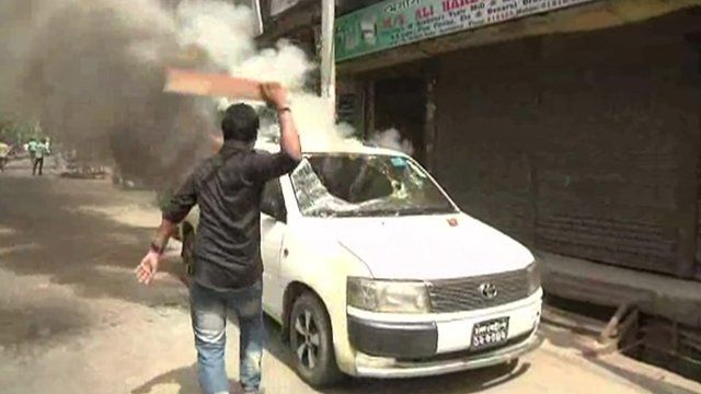 Protester striking car with baton