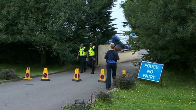 Police at the entrance to the farm
