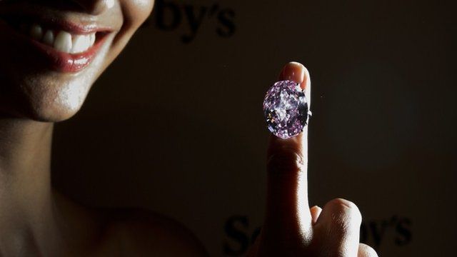 A model shows a 59.6-carat pink diamond that will be auctioned by Sothebys in the Swiss city of Geneva in November