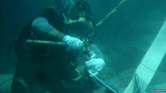 Scuba diver chips at coral reef