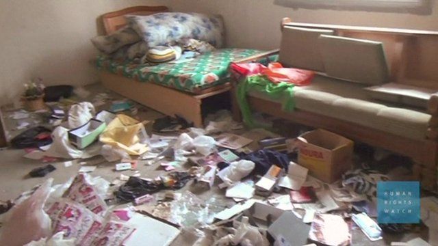 A room with scattered belongings on the floor