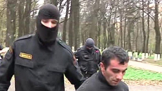 Masked special forces holding suspect