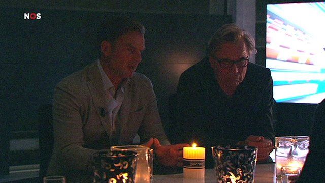 Sports pundit discuss the action by candlelight