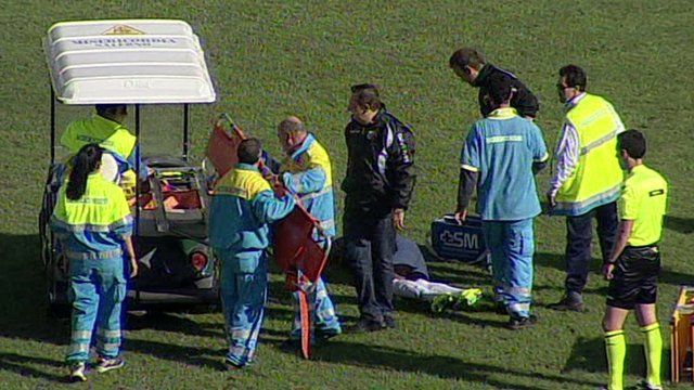 Officials help an injured player