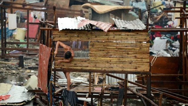 A man reconstructs his destroyed house in Tacloban, eastern island of Leyte