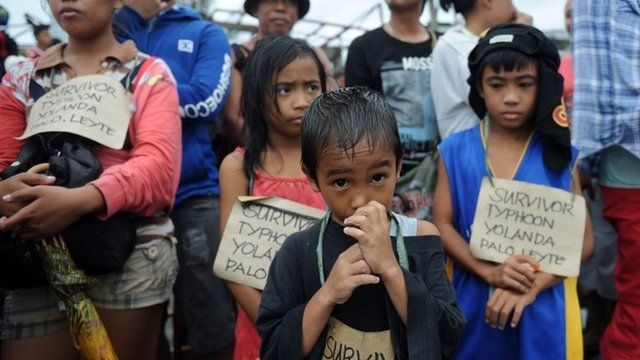 Survivors of the super Typhoon Haiyan, wait for a C-130 military plane at Tacloban airport, Leyte province, central Philippines