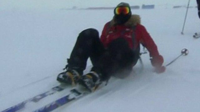 Prince Harry sits on snow in skis after falling over