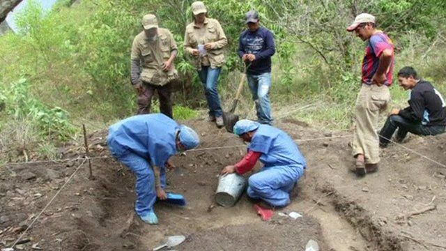Forensic teams works on a mass graves