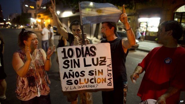 Four protesters with Argentinean flag and sign in Spanish