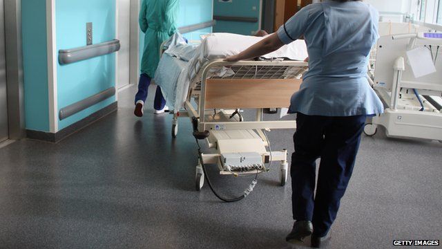 A nurse pushing a hospital bed