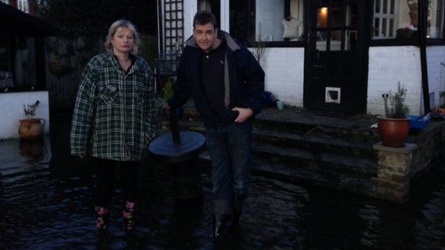 Local residents Deborah Carter and Gavin Segar stand in floodwater