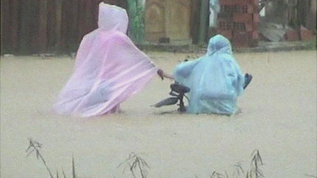 A woman and a boy on a bicycle try to pass through a flooded area in Rurrenabaque in northern Bolivia