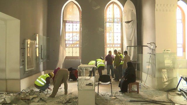 Workers cleaning up debris in museum