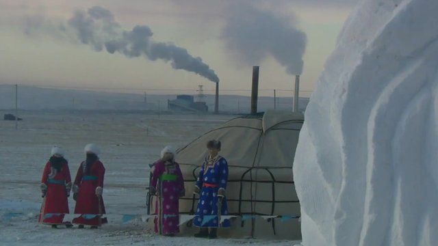 Smoking chimneys behind traditional yurt