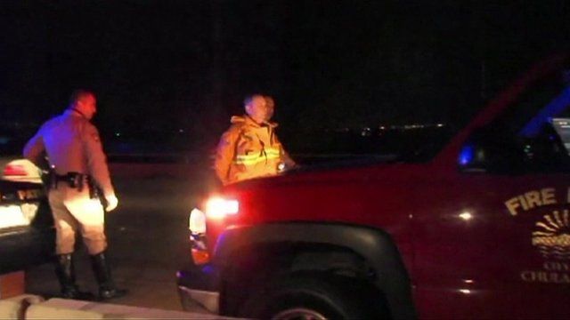 A firefighter is handcuffed by Highway Patrol officers