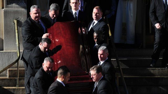 Pallbearers carry his coffin