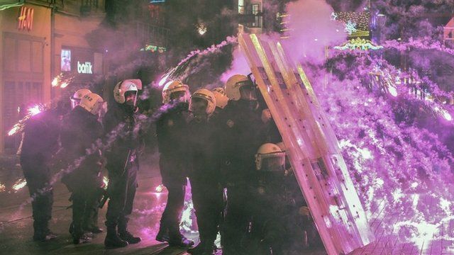 Riot police taking cover