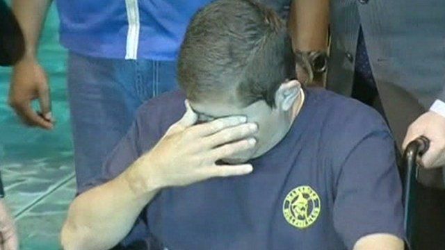 Mr Alvarenga covers his eyes as he arrives in El Salvador