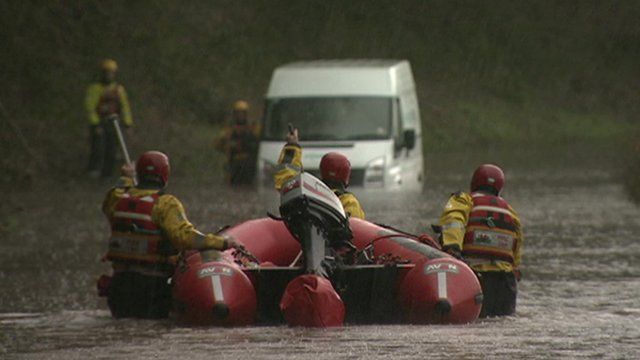 Firemen with dinghy wading out to van