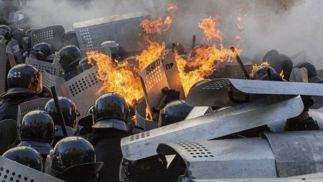 Flames erupt around Interior Ministry police during clashes with anti-government protesters in Kiev on Tuesday