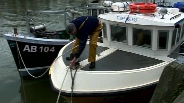 fisherman tying rope on boat