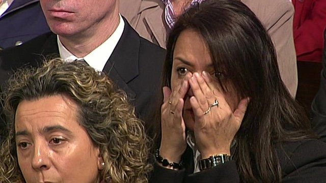 A mourner wipes away tears at a service in Madrid to mark the 10th anniversary of train bomb attacks