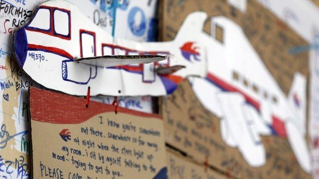 A message card is seen below a paper plane of a Malaysian airliner, on the message board for passengers aboard a missing Malaysia Airlines plane at Kuala Lumpur International Airport