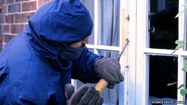A burglar breaking into a house
