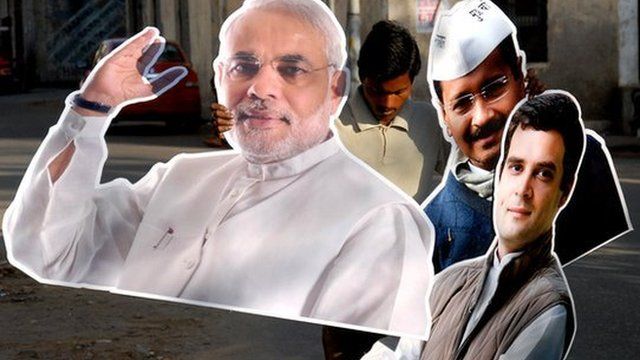 Man holding cardboard cut-outs of Indian election candidates