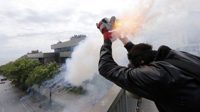 A protester shoots firecrackers at riot police during a May Day demonstration in Istanbul May 1, 2014