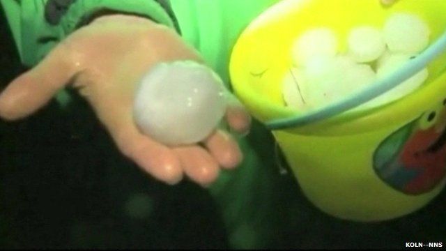 Hand holds bucket of giant hail stones in Wilber, Nebraska